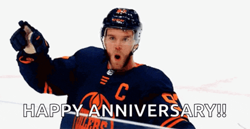 a hockey player is pointing at the camera and says happy anniversary !