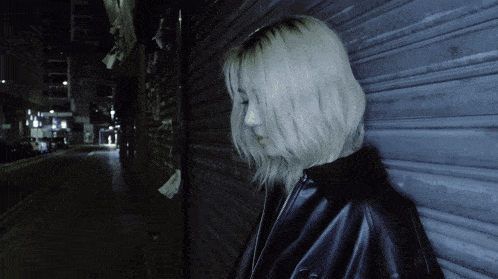 a woman leaning against a wall with a sign that says ' motel ' on it
