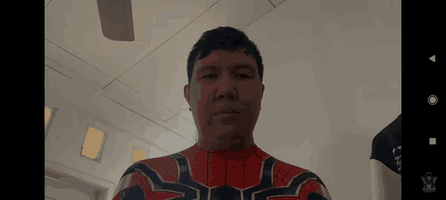 a man in a spiderman costume is standing in a room