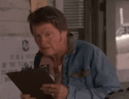 a man in a denim jacket is holding a clipboard in his hand .