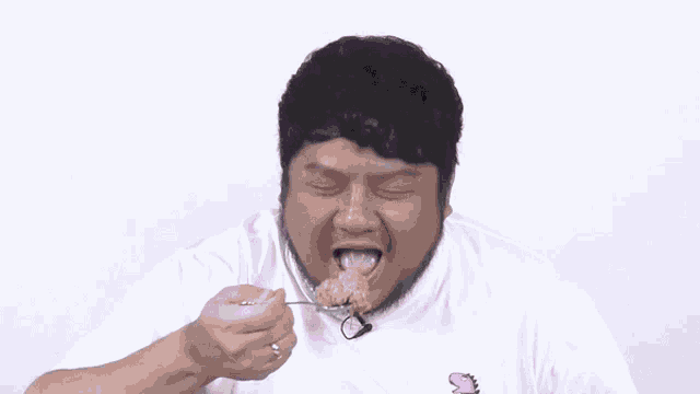 a man in a white shirt is eating something with the words yummy and immmm behind him