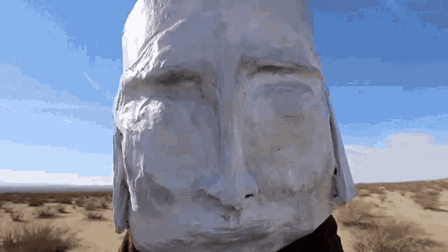 a statue of a man 's face is covered in white plastic