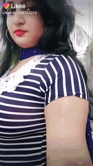a woman is wearing a striped shirt and a blue choker
