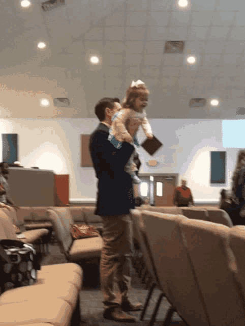 a man is holding a little girl in his arms