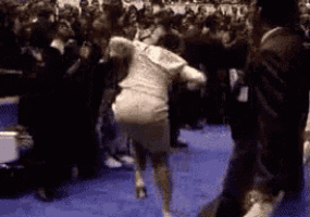 a woman in a white dress is running in front of a crowd .