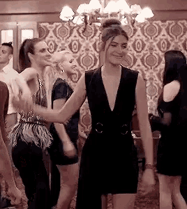 a group of women are dancing in a room at a party .
