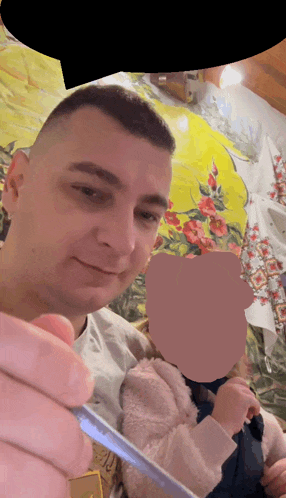 a man is holding a child with a blurred image of the child