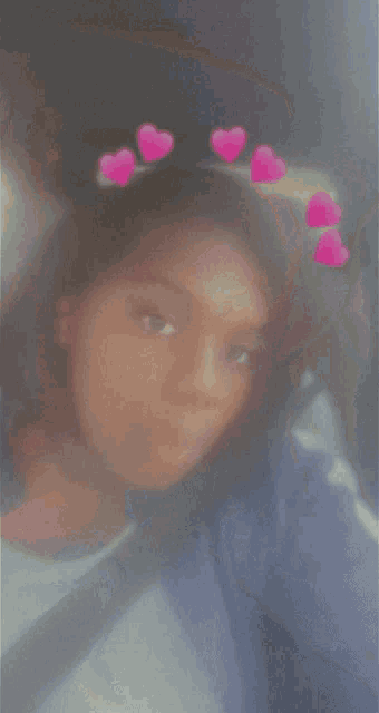 a blurry photo of a girl with pink hearts on her head