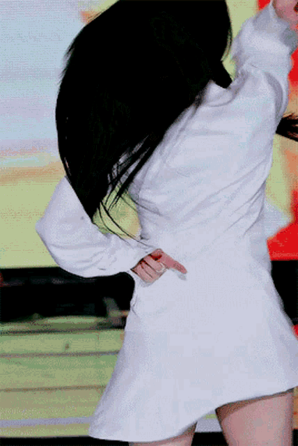a woman in a white dress is dancing on stage