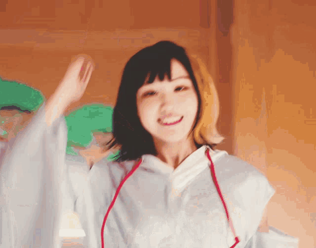 a woman with a white shirt and red string around her neck is smiling