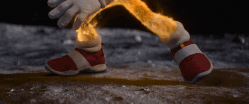 a close up of a sonic the hedgehog 's foot with a fire coming out of it