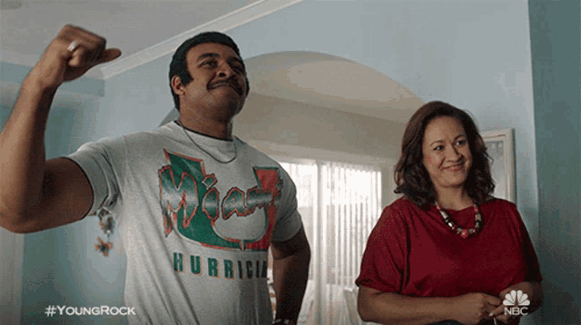 a man wearing a miami hurrican shirt flexes his muscles