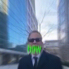 a man in a suit and tie has the word now in his mouth .