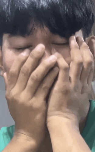 a person covering their face with their hands
