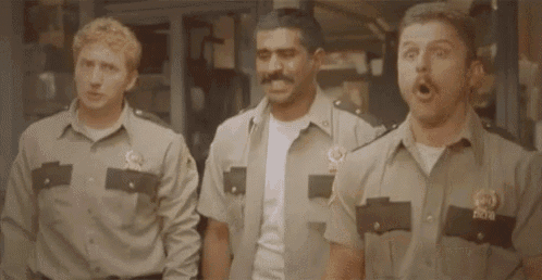 three police officers are standing next to each other and holding guns .