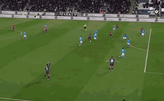 a soccer game is being played in front of a banner that says gaudi jeans