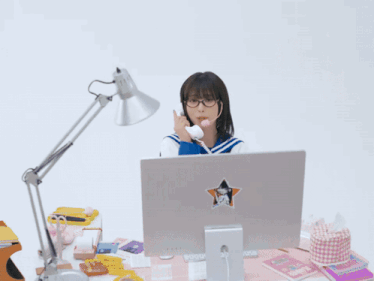 a girl wearing glasses and a pink headset talks on a phone