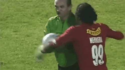 a man in a red jersey with the number 99 on it is holding a soccer ball