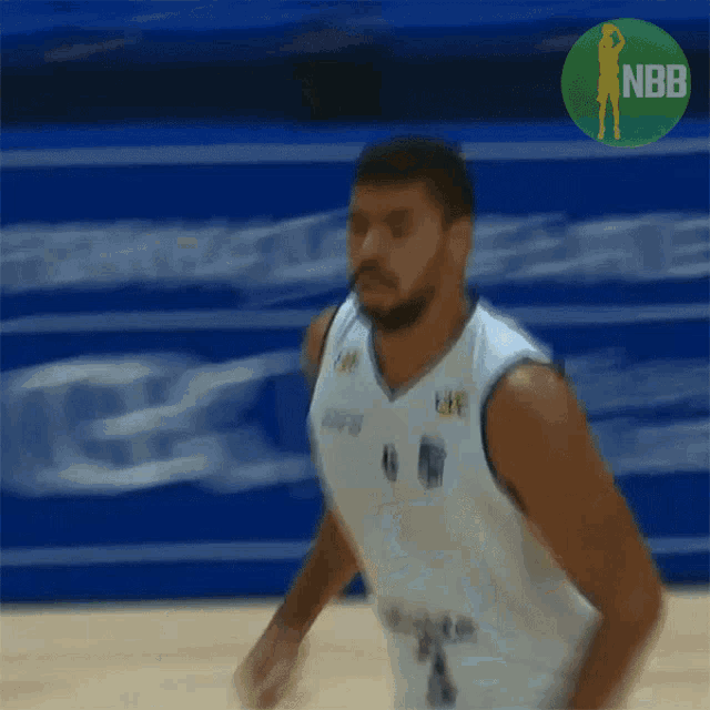 a basketball player in a white jersey with a nbb logo in the background