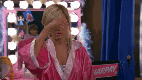 a woman in a pink robe covering her eyes in front of a chair that says harpay