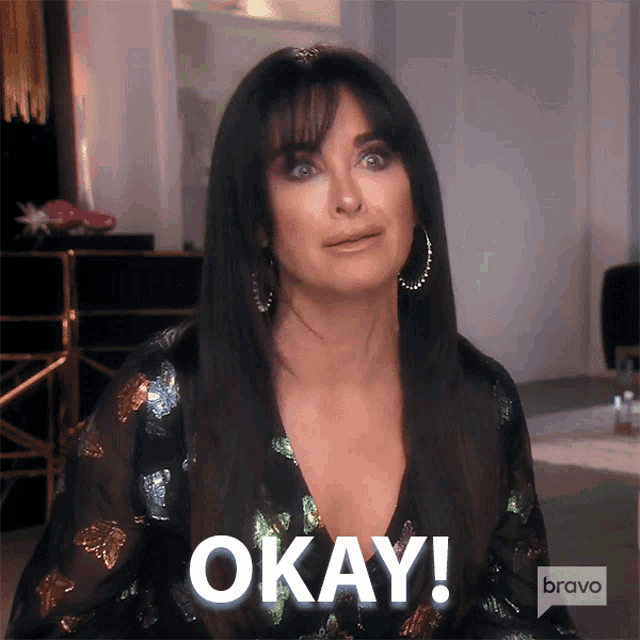 a woman in a black dress says okay in white letters