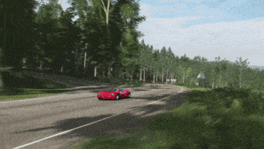 a red car is driving down a road with trees on the side