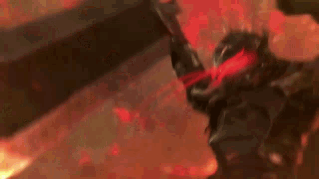 a sword is being held in front of a fire in a dark room .