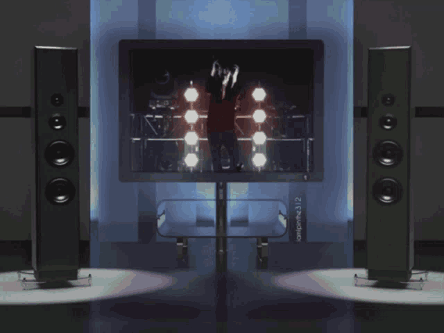 a tv with a picture of a woman playing a guitar is surrounded by two speakers