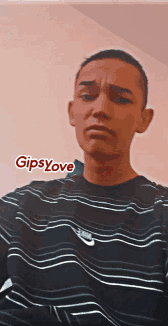 a young man wearing a black and white striped shirt with the word gipsylove on the bottom right