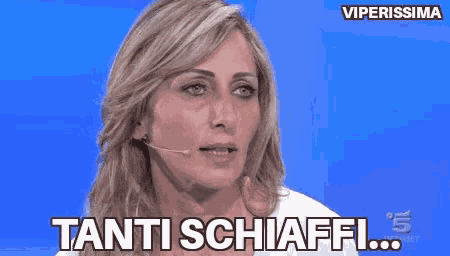 a woman with a microphone on her head says tanti schiaffi .