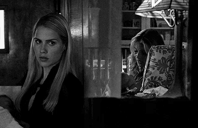 a black and white photo of two women in a room .