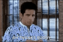 a man is standing in front of a window wearing a penguin pajamas and saying `` ah thanks buddy '' .