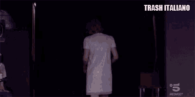 a woman in a white dress is standing in front of a black background .