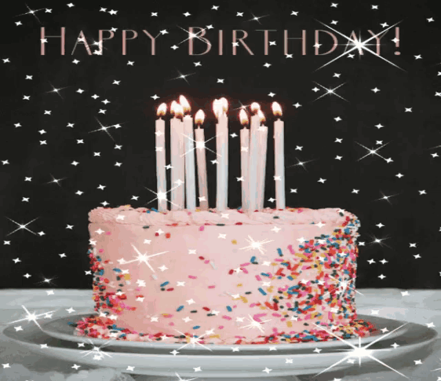 a pink birthday cake with candles and sprinkles with the words happy birthday written in the background
