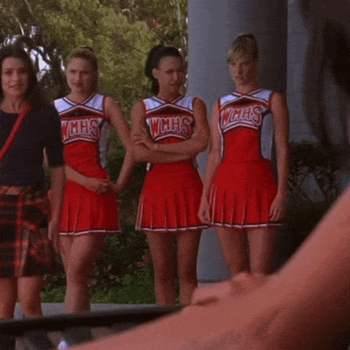 a group of cheerleaders wearing wmhs uniforms are standing next to each other