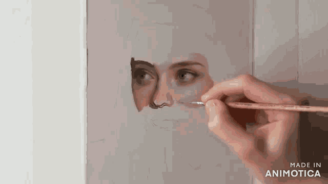 a person is painting a woman 's face with a brush and the words made in animotica are on the bottom