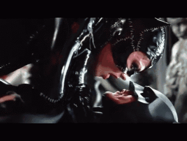 a woman in a catwoman costume is licking a man 's face