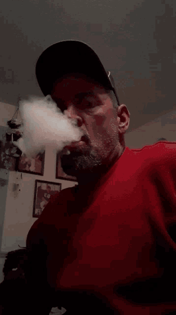 a man in a red shirt smoking a cigarette