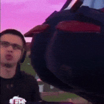 a man wearing headphones is standing in front of a giant cartoon character .