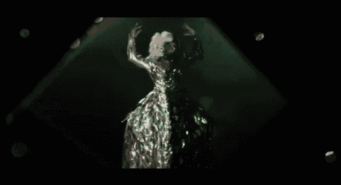 a woman in a long green dress is dancing on a stage .