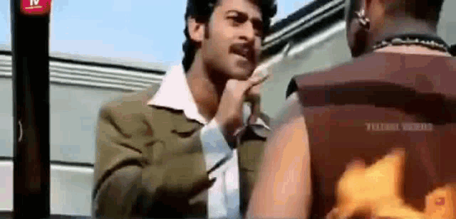 a man with a mustache is talking to another man in a movie .