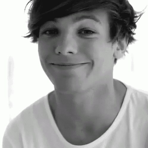a black and white photo of a young boy smiling .