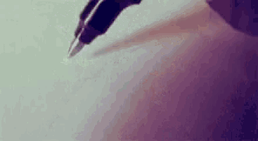 a close up of a person writing with a fountain pen on a piece of paper .