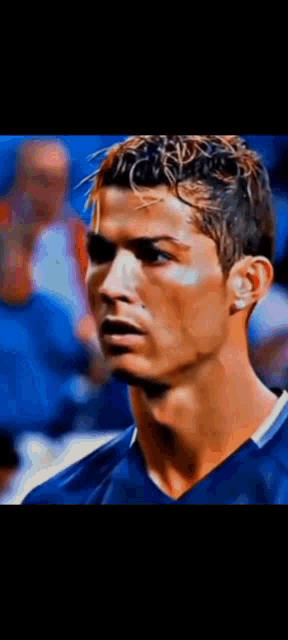 a close up of a man 's face with a blue shirt on .
