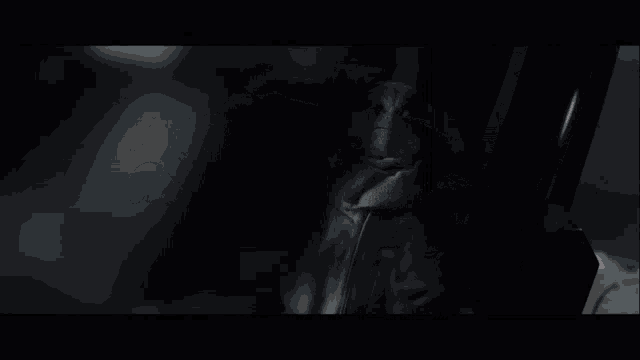 a dark room with a shadow of a person in the corner