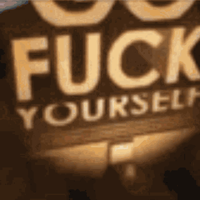 a brown sign that says fuck yourself on it