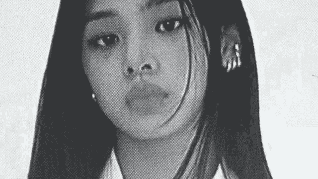 a black and white photo of a young girl with long hair and earrings .