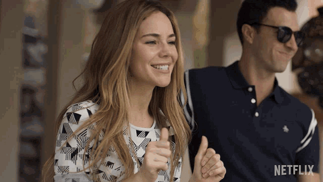 a woman giving a thumbs up next to a man with a netflix logo