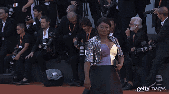 a woman waving on a red carpet with the words getty images on the bottom