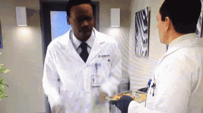 a man in a lab coat is talking to another man in a lab coat .